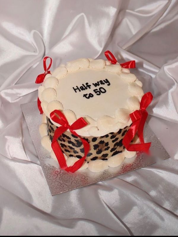 A red and leopard cake crowned with cherries