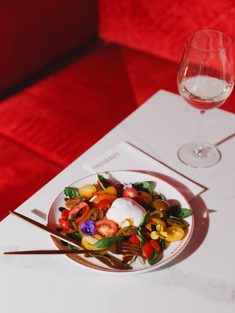 Burrata and tomatoes on the red banquette