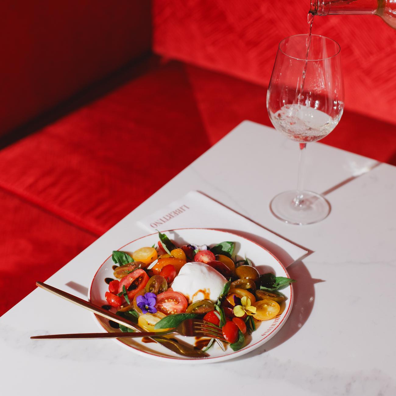 A glass of wine on the red banquette