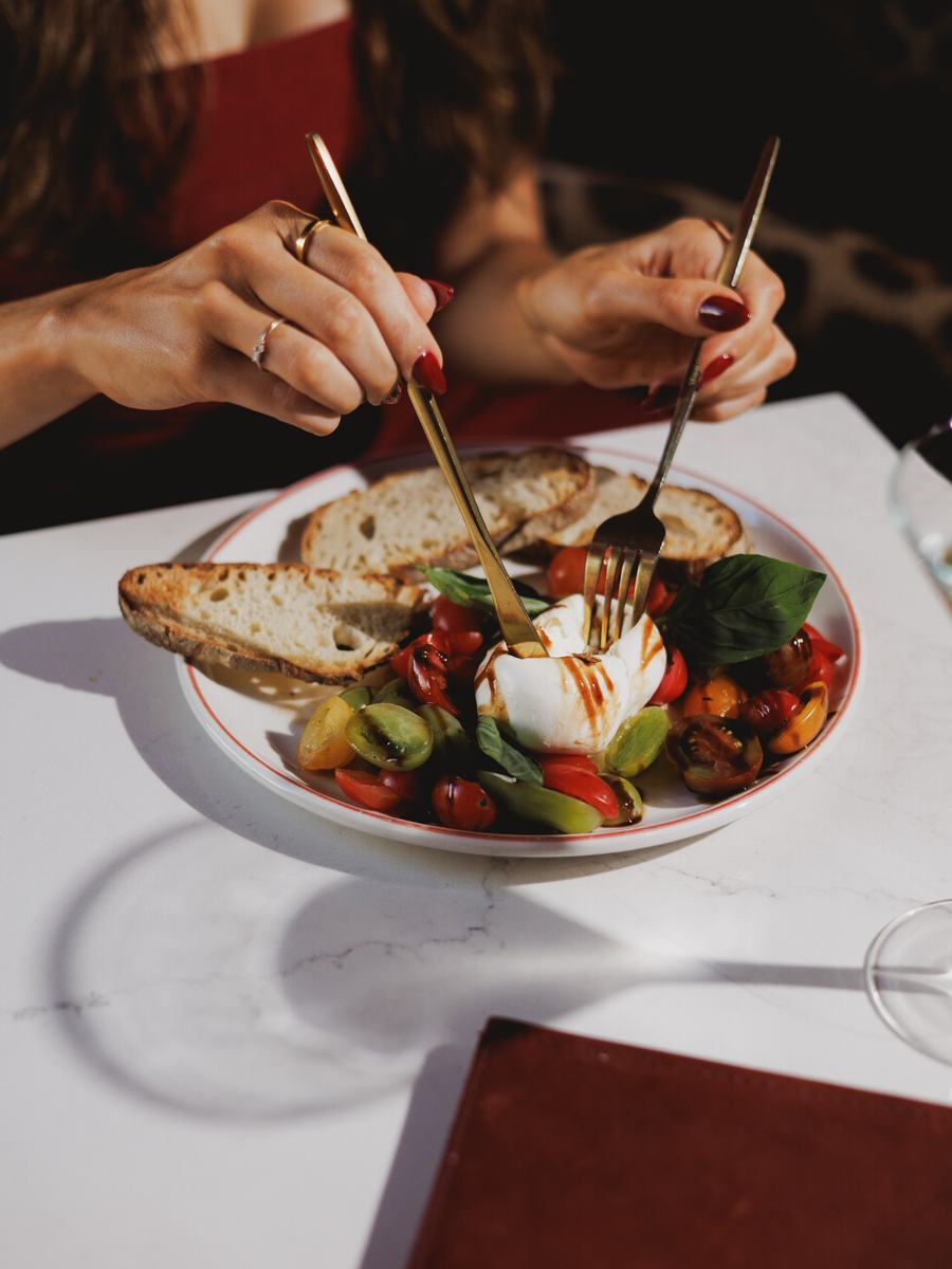 Burrata and tomatoes being served