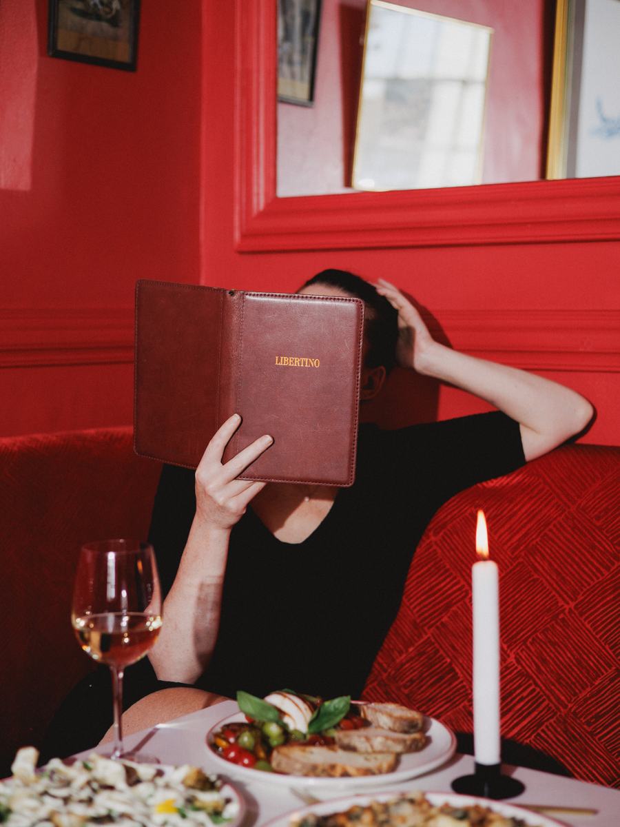A guest reading the menu in the corner banquette